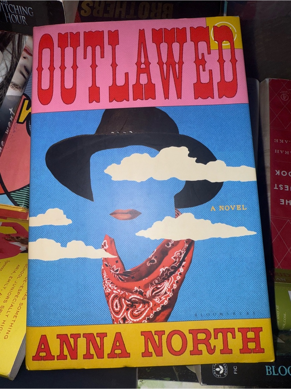 Outlawed by Anna North — Blue, Pink & Yellow Hard Cover